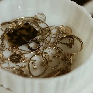 A dish of gold-tone costume jewelry