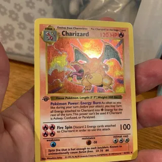 A 1st Edition Base Set Charizard holo Pokémon card, held in hand