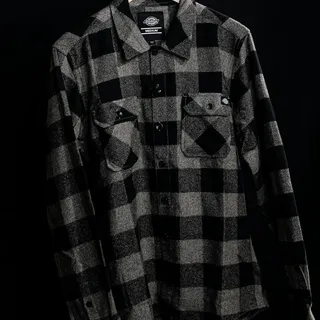 A Dickies black and gray plaid flannel shirt on a hanger